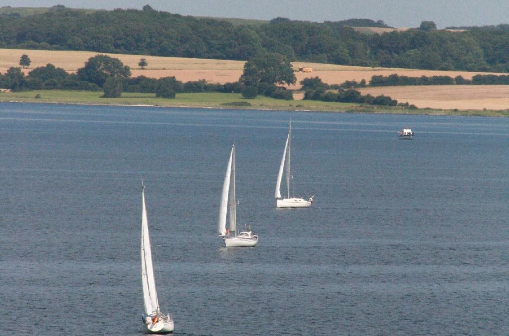 Drei Segelboote auf dem Wasser bei Langballig. Im Hintergrund Land