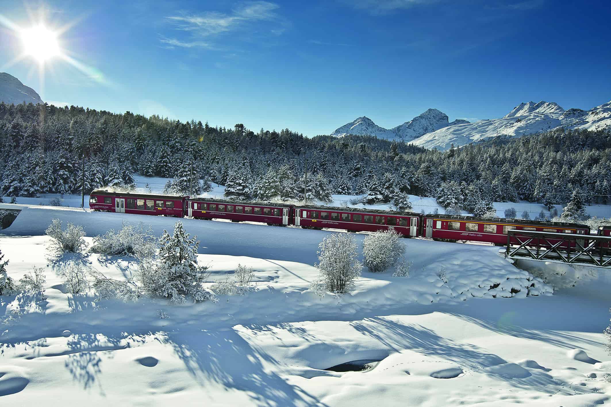 Alpen entdecken: Die Rhätische Bahn fährt durch die Winterlandschaft der Schweiz.