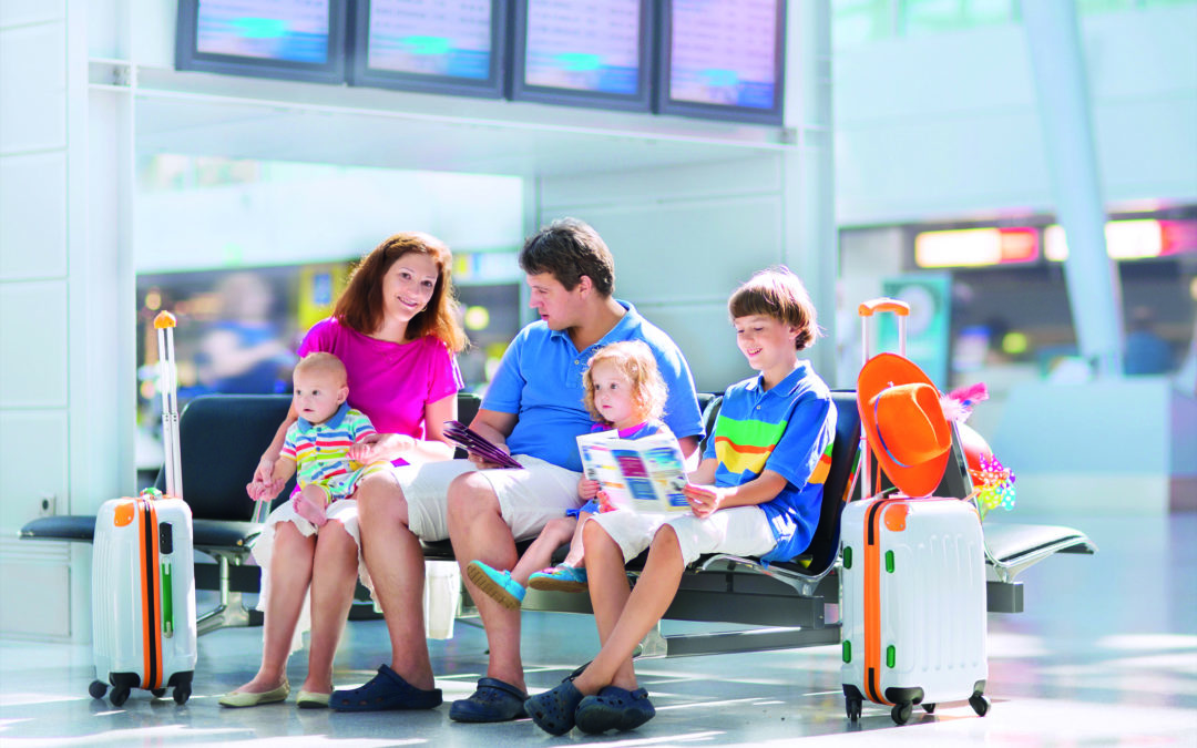 Eine Familie sitzt zufrieden auf einer Sitzgelegenheit im Flughafen. Sie haben alle Reisevorbereitungen im Voraus getroffen und sind nun bereit für den gemeinsamen Urlaub.
