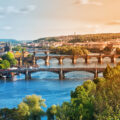 Zusehen ist die Stadt Prag mit der Karlsbrücke, welche die Moldau kreuzt.