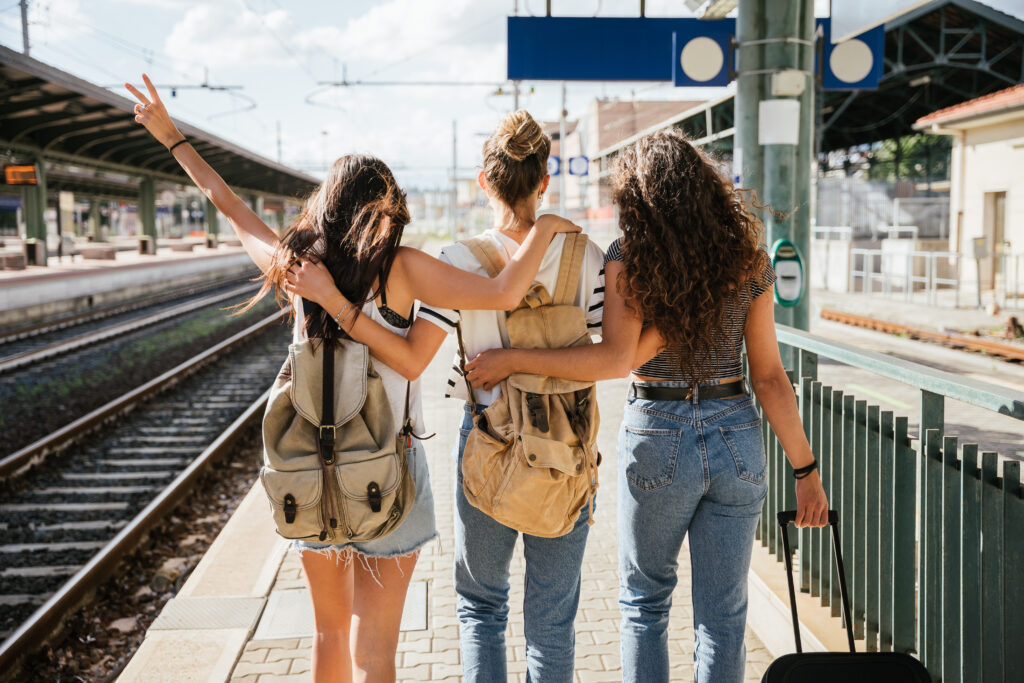 Drei Frauen am Gleis, freuen sich auf ihren Zug, in den Urlaub.
